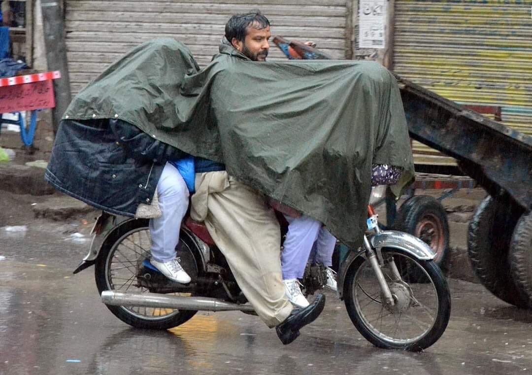 Father cover daughters from rain while wet himself