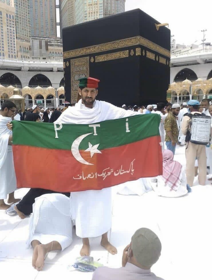 PTI supporter holds flag wearing cap in Ihram in Kaaba Baitullah